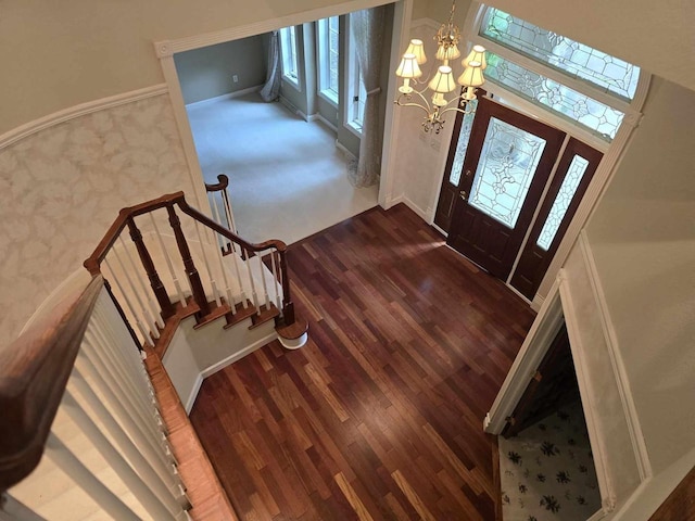 entrance foyer with a towering ceiling, dark hardwood / wood-style floors, and a chandelier