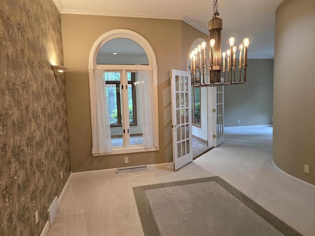 unfurnished dining area with crown molding, an inviting chandelier, and french doors