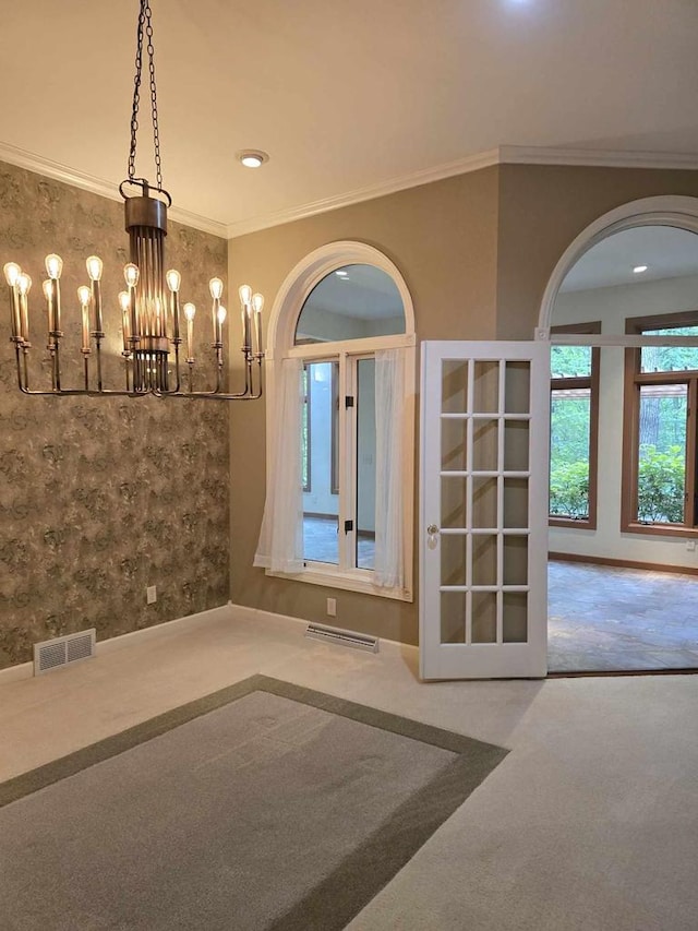 spare room with ornamental molding and a chandelier