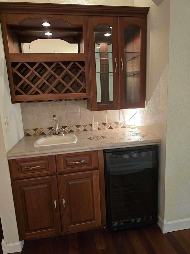 bar featuring wine cooler, sink, tasteful backsplash, and dark hardwood / wood-style flooring