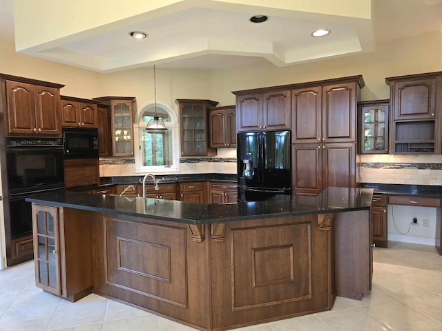 kitchen featuring dark brown cabinetry, decorative backsplash, black appliances, and a spacious island