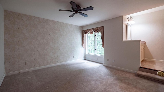 carpeted spare room featuring ceiling fan