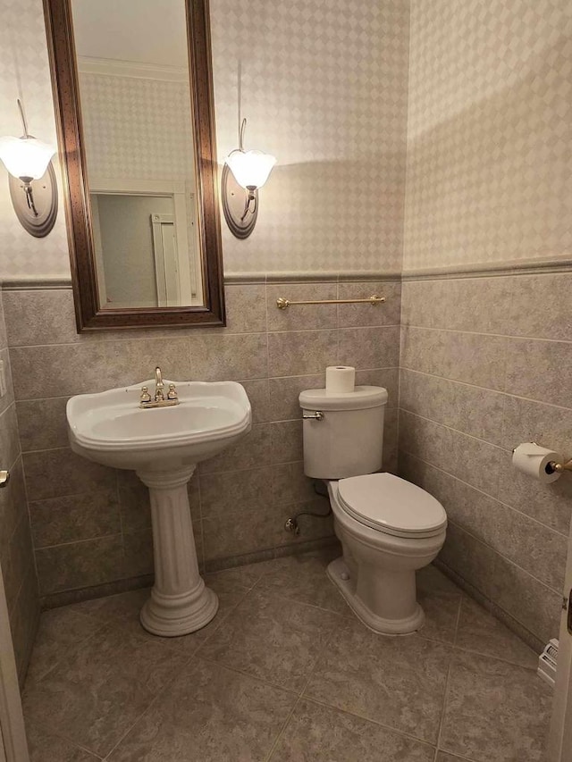 bathroom featuring tile patterned flooring, tile walls, and toilet