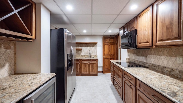 kitchen with wine cooler, sink, tasteful backsplash, and black appliances