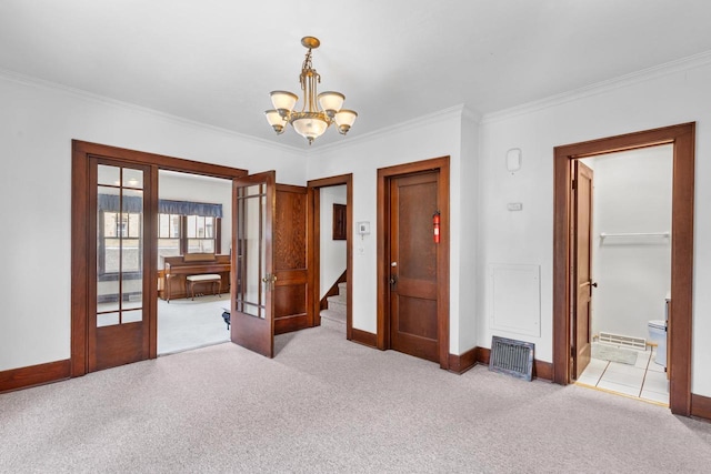 interior space with a notable chandelier, light colored carpet, ornamental molding, and french doors