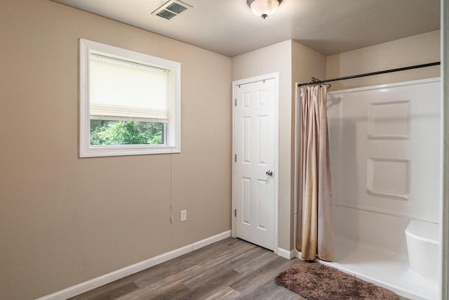 bathroom with curtained shower and hardwood / wood-style flooring