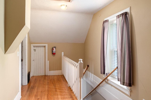 stairs with hardwood / wood-style flooring and lofted ceiling