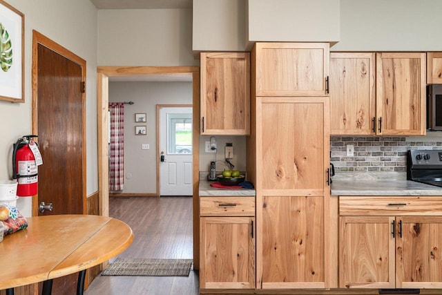 kitchen with decorative backsplash, light brown cabinets, and dark hardwood / wood-style floors