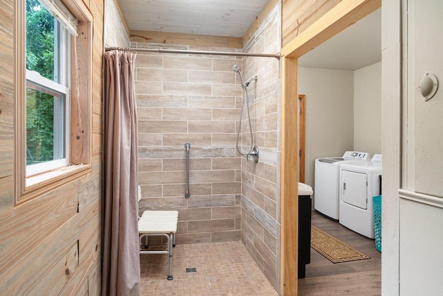 bathroom featuring hardwood / wood-style floors, separate washer and dryer, a wealth of natural light, and curtained shower