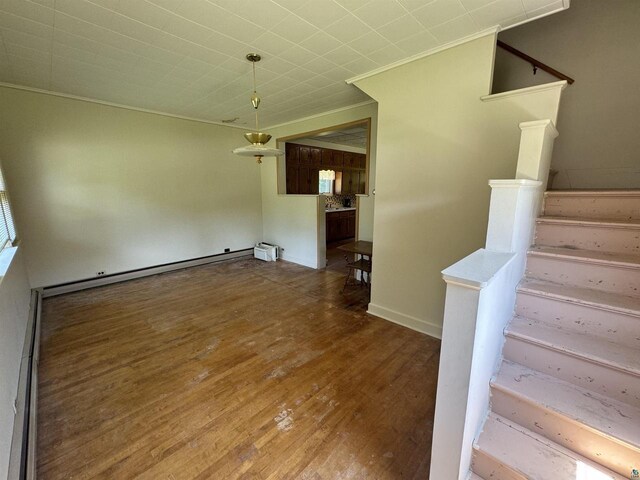 interior space featuring hardwood / wood-style floors, a baseboard radiator, and crown molding