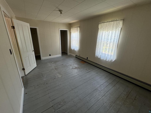 spare room featuring hardwood / wood-style floors and a baseboard heating unit