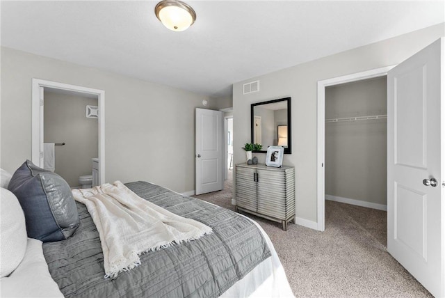 carpeted bedroom featuring connected bathroom and a closet