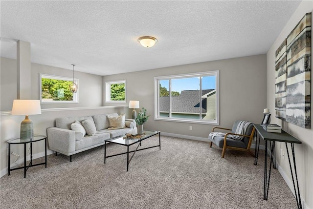 living room with carpet floors, a healthy amount of sunlight, and a textured ceiling