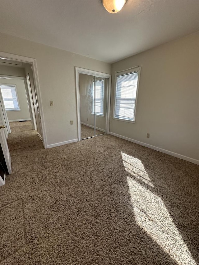 unfurnished bedroom with a closet, carpet flooring, and baseboards