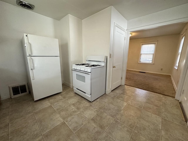 kitchen featuring white appliances, visible vents, and baseboards