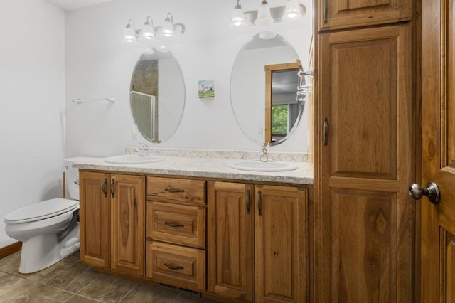 bathroom featuring vanity, toilet, and a shower with shower door