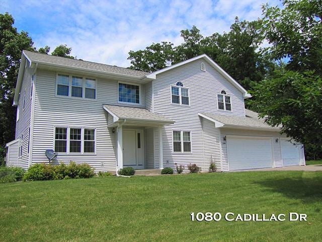 front facade with a front lawn and a garage