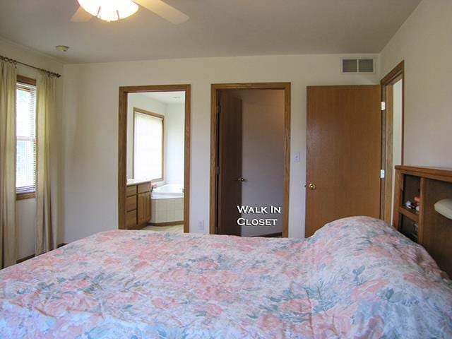 bedroom with ensuite bath and ceiling fan