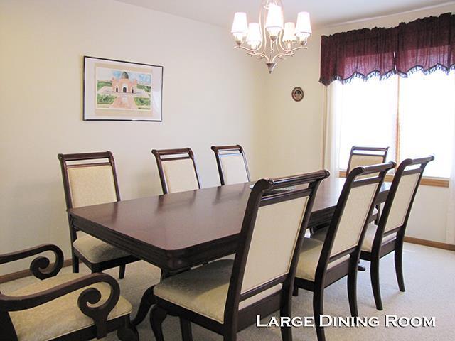 dining space featuring light colored carpet and a chandelier