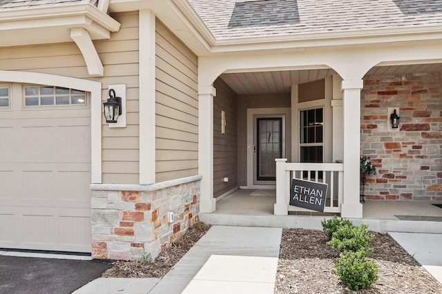 view of exterior entry with covered porch and a garage