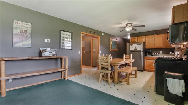 kitchen with stainless steel refrigerator, ceiling fan, and sink