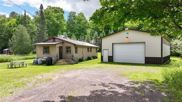 view of front facade featuring a front lawn, an outdoor structure, and a garage