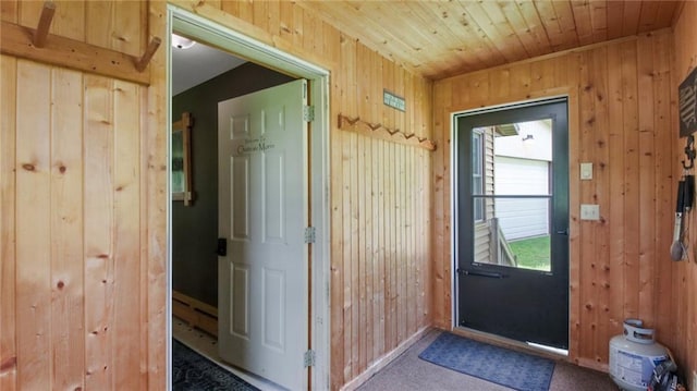 entryway featuring wooden ceiling and wooden walls