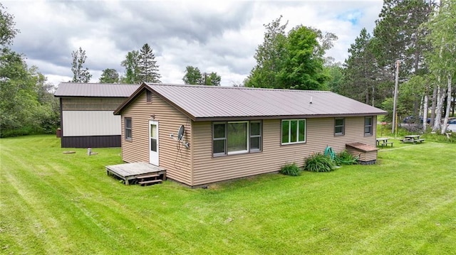 back of property with a lawn and a wooden deck