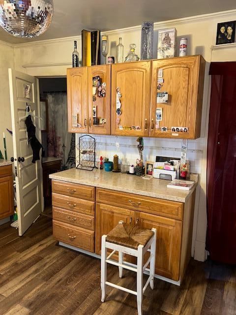 kitchen featuring tasteful backsplash, ornamental molding, and dark hardwood / wood-style floors