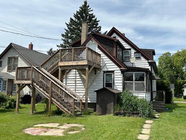 back of property featuring a yard and a deck