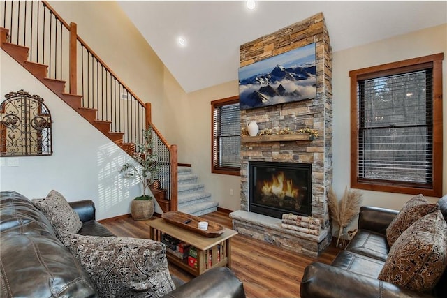 living room with a stone fireplace and wood-type flooring