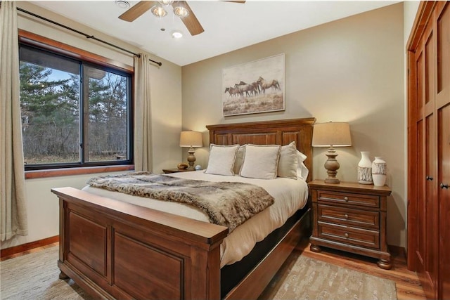 bedroom with light hardwood / wood-style flooring and ceiling fan