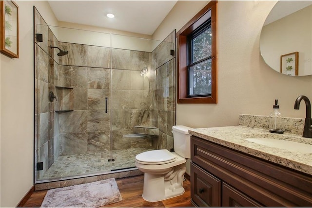 bathroom with vanity, hardwood / wood-style flooring, toilet, and a shower with shower door