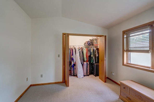 carpeted bedroom with vaulted ceiling and a closet