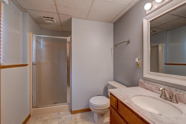 bathroom with vanity, toilet, a drop ceiling, and walk in shower