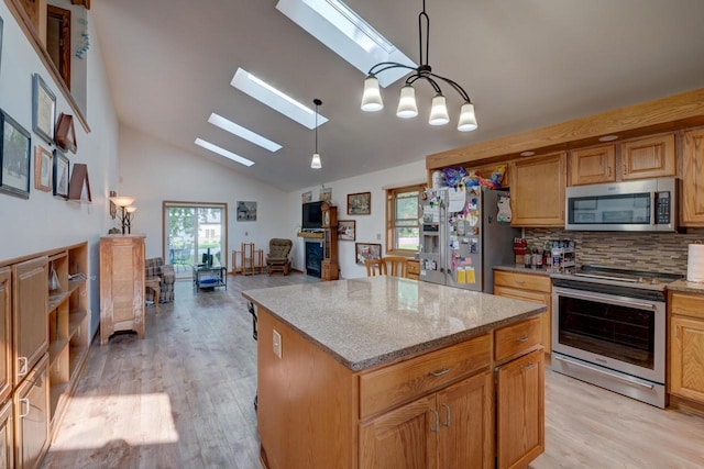 kitchen featuring backsplash, hanging light fixtures, a skylight, stainless steel appliances, and a center island