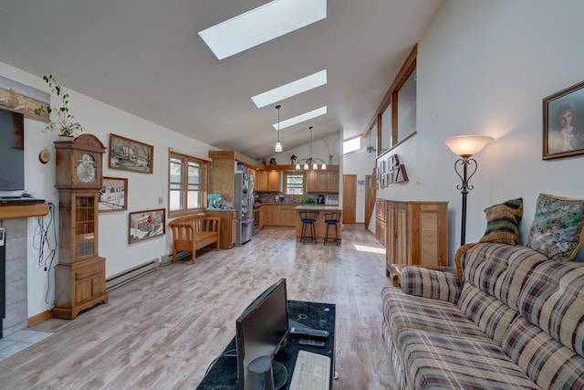 living room with a skylight, a baseboard radiator, high vaulted ceiling, light hardwood / wood-style flooring, and a notable chandelier