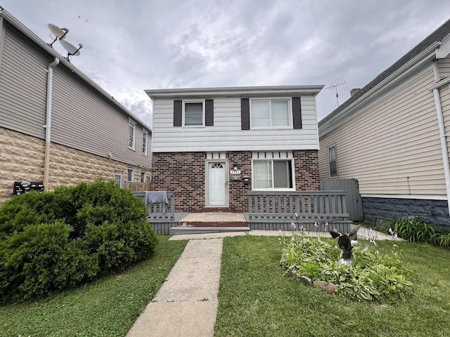 view of front of home with a wooden deck and a front lawn