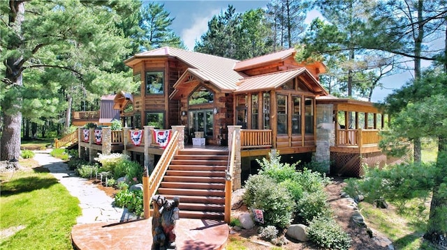 rear view of house with a wooden deck and a sunroom