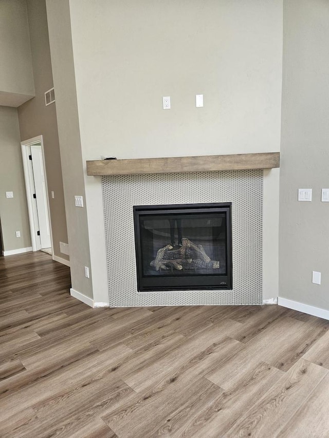 room details with a tiled fireplace and hardwood / wood-style floors