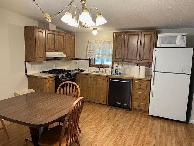 2217 Blackhawk St, Friendship, WI 53934 - kitchen with pendant lighting, white appliances, an inviting chandelier, decorative backsplash, and light wood-type flooring