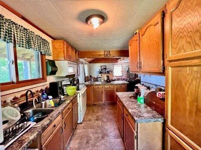 kitchen featuring white appliances, stone countertops, and sink