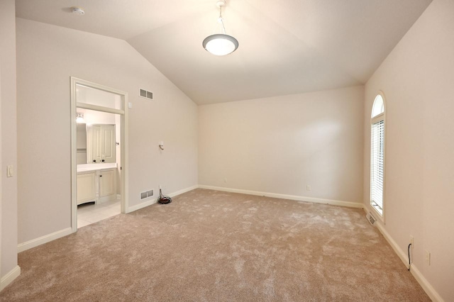 unfurnished room with light carpet and vaulted ceiling