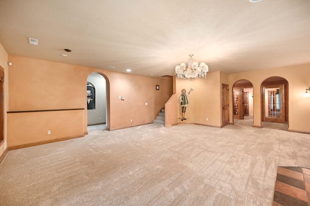 empty room featuring light carpet and an inviting chandelier