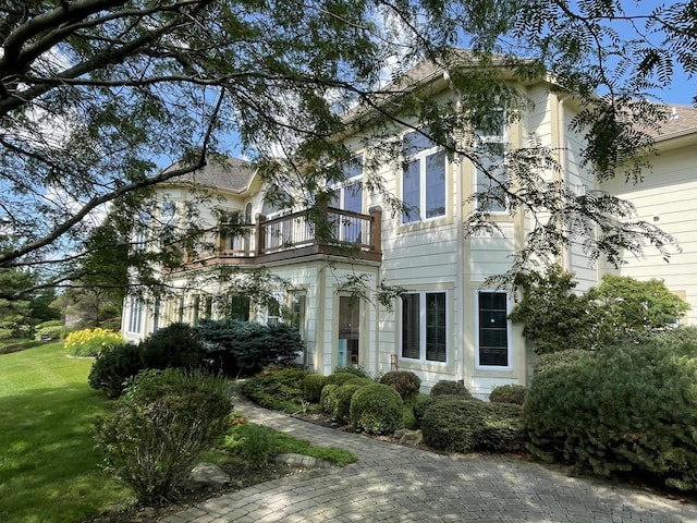 view of front facade with a front yard and a balcony