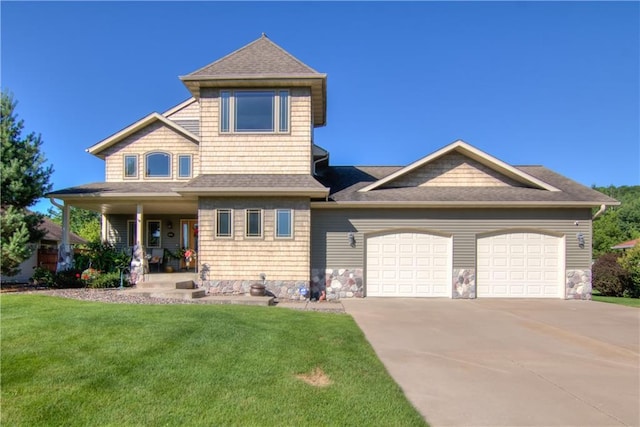 view of front of home featuring a porch, a front yard, and a garage