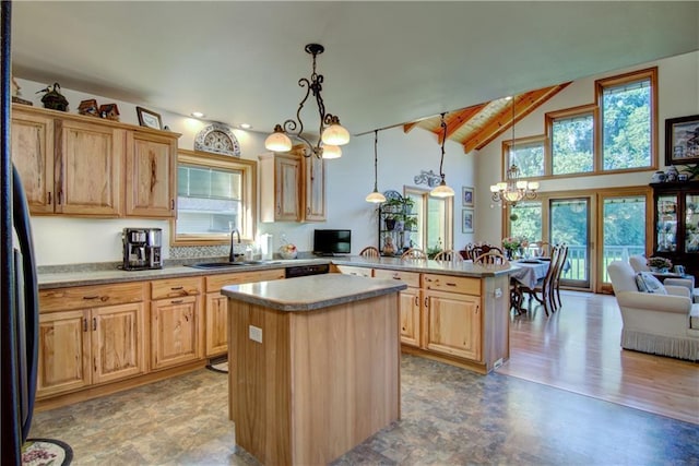 kitchen with pendant lighting, a center island, sink, a notable chandelier, and kitchen peninsula