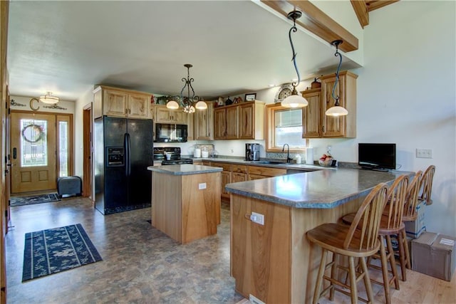 kitchen featuring kitchen peninsula, decorative light fixtures, a wealth of natural light, and black appliances