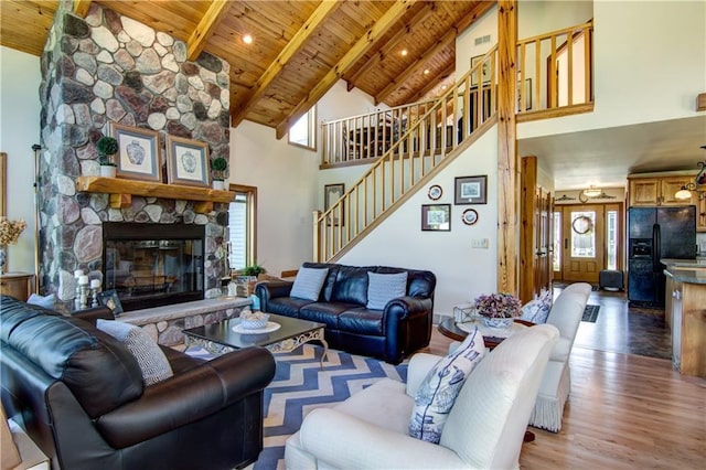 living room featuring beamed ceiling, wood ceiling, a fireplace, and high vaulted ceiling