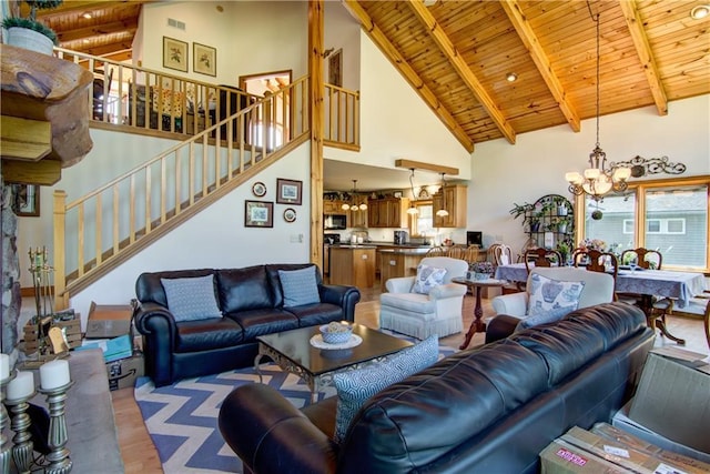 living room featuring beam ceiling, high vaulted ceiling, a notable chandelier, wood ceiling, and light wood-type flooring